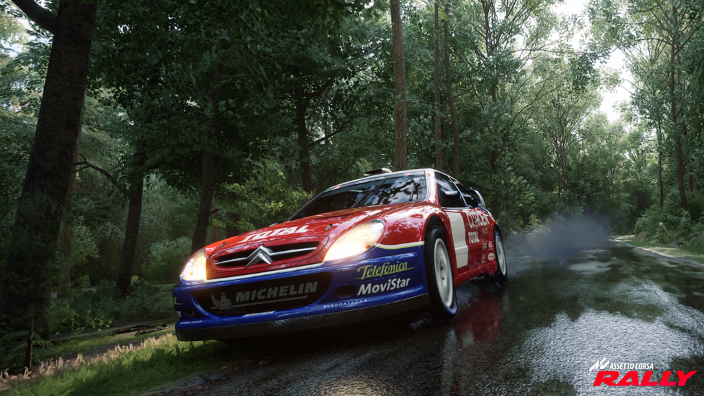 A Citroën Xsara WRC charges through a wet forest stage in Assetto Corsa Rally, spraying water from the slick asphalt as it accelerates out of a bend. The vibrant red and blue livery contrasts with the dense green trees and reflective road surface, highlighting the game’s realistic lighting, detailed car models, and dynamic weather effects.